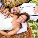 bride and groom laying on picnic blanket tapestries