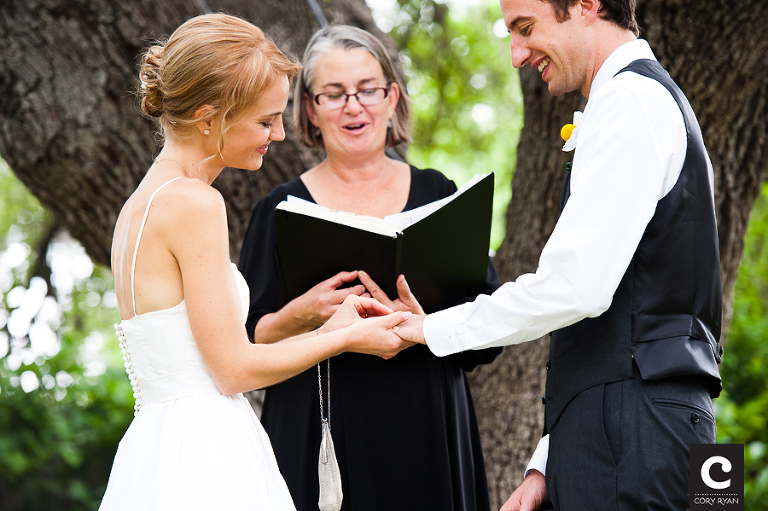 bride putting on grooms wedding ring