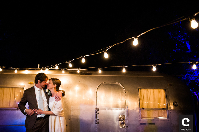 bride and groom at night with airstream trailer