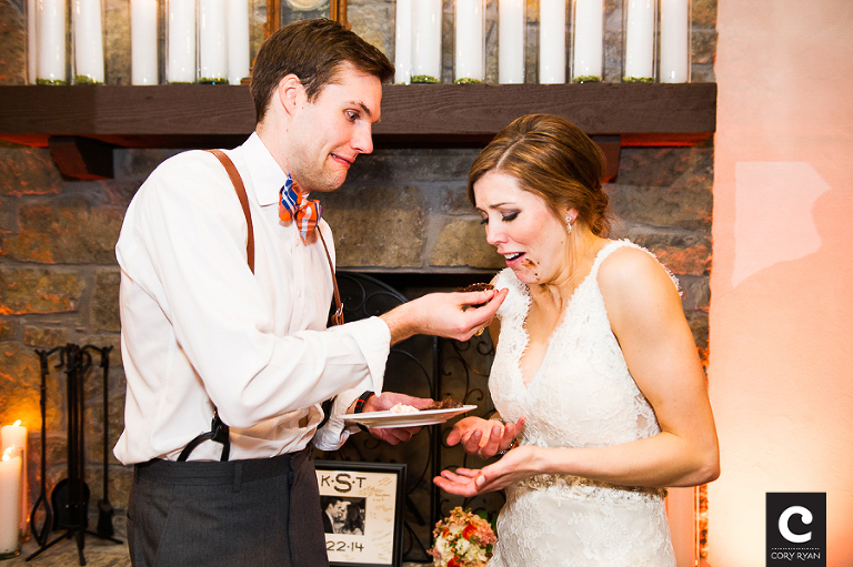 groom almost drops chocolate cake on the bride's dres