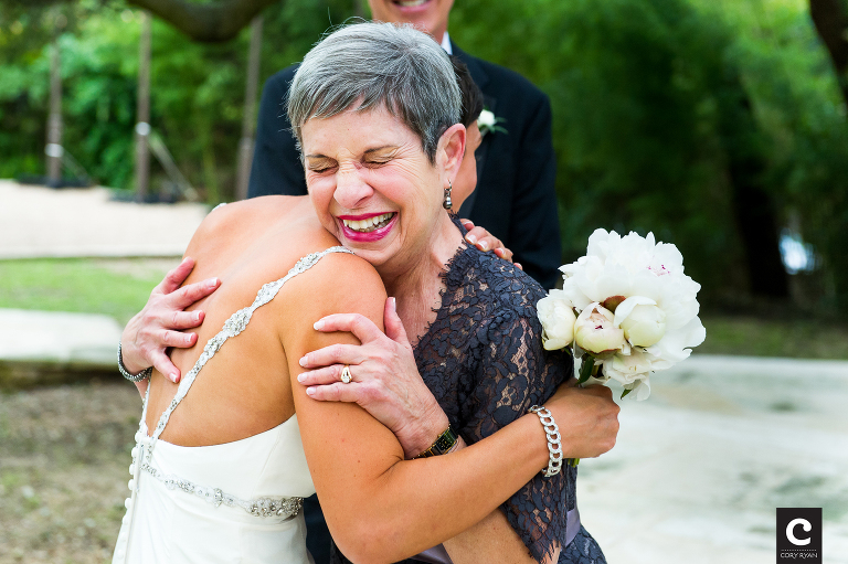 mom cries as she hugs the bride