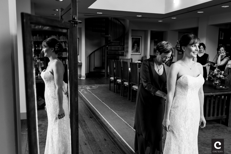 bride with mom getting on her wedding dress