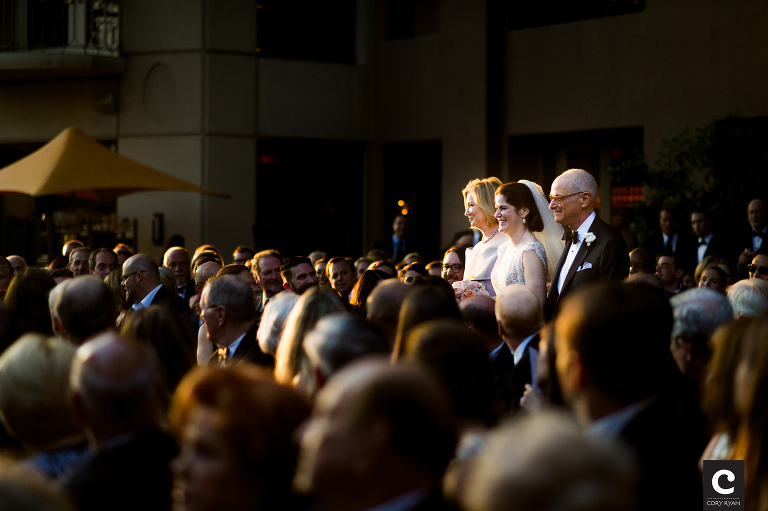 bride walking down aisle with mom and dad