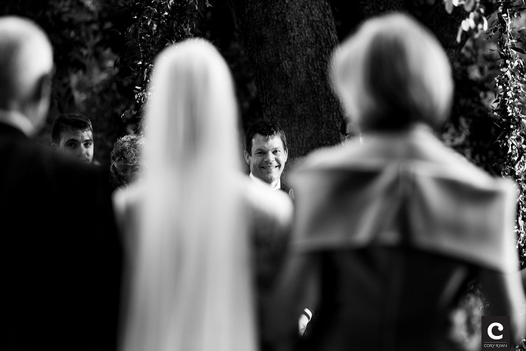 groom smiles at bride coming down the aisle