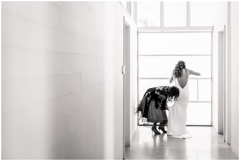 mom helping her daughter with her wedding dress